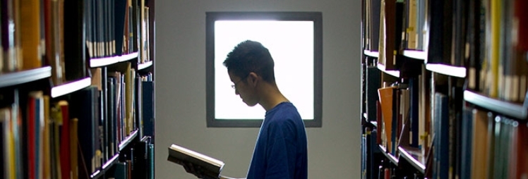 A man reads a book in a library