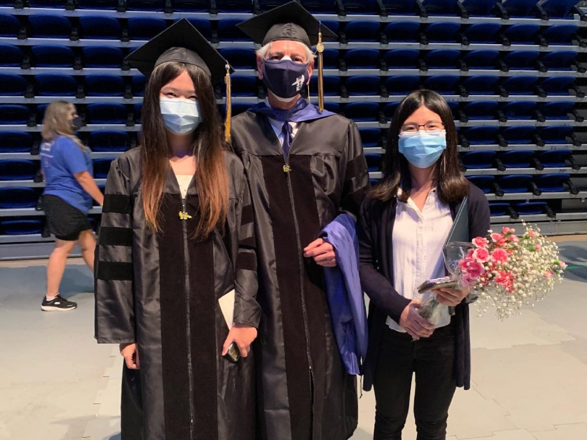 Picture of two graduate students and an advisor and Graduate Hooding 2021
