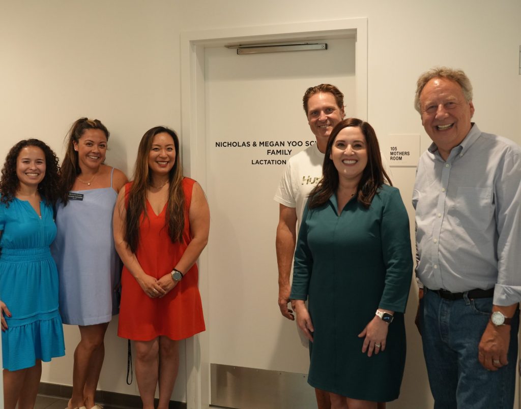 The leaders of the UCI Graduate Division and Housing Department staff posing with Megan and Nicholas in front of their lactation room