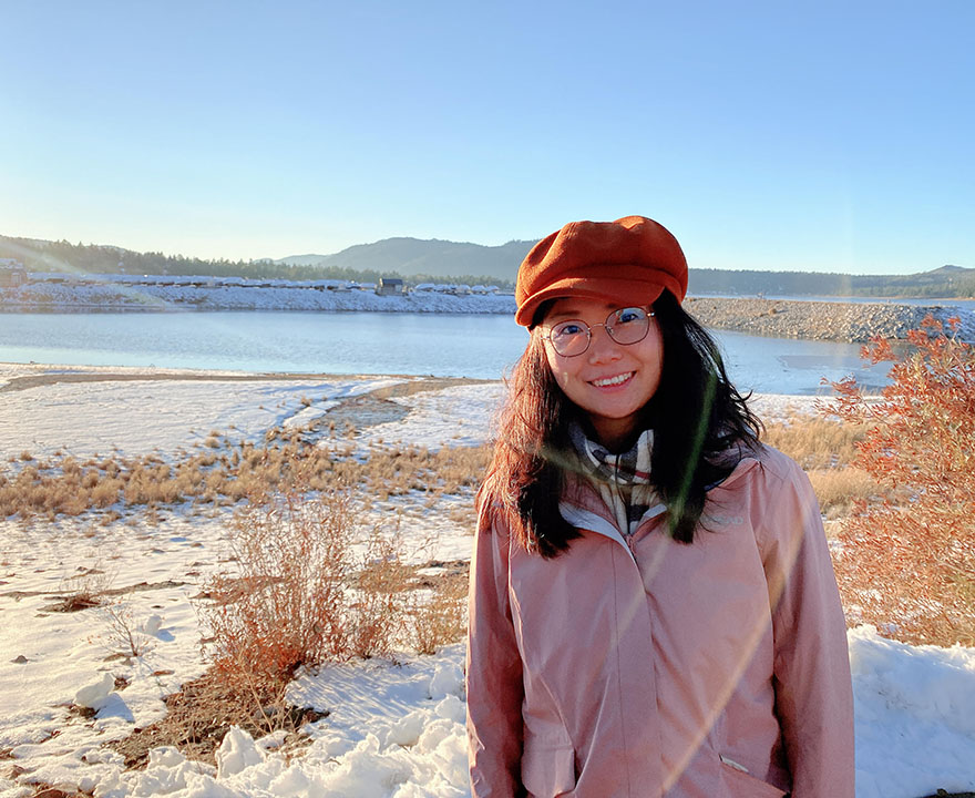 Jiaxuan Li posing in front of a lake with snow on the ground